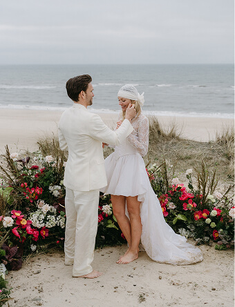 SAY WOW Karina von Ende Hochzeit auf Sylt Brautpaar steht am Strand, die Braut trägt ein luftiges weißes Kleid