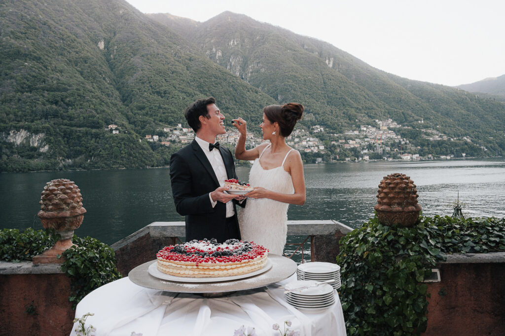 Hochzeitstorte wird am Steg vor dem Comer See angeschnitten